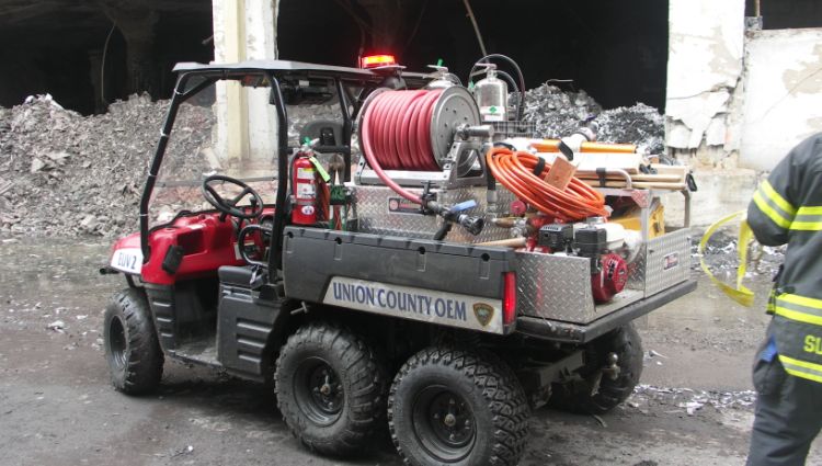 Firefighting Utv In Front Of Partially Demolished Building.
