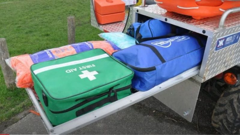 A first aid kit and other equipment on the back of a utility vehicle.