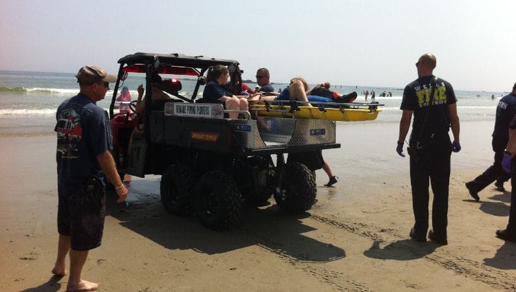 A patient being loaded onto a UTV with a specialized skid unit.