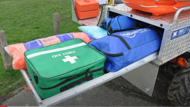 A First Aid Kit And Other Equipment On The Back Of A Utility Vehicle. - Kimtek Corporation A First Aid Kit And Other Equipment On The Back Of A Utility Vehicle.